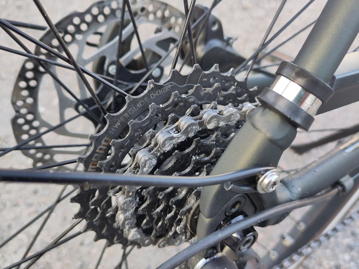 A bicycle chain installed into place. It has small wax pieces torn from it.
