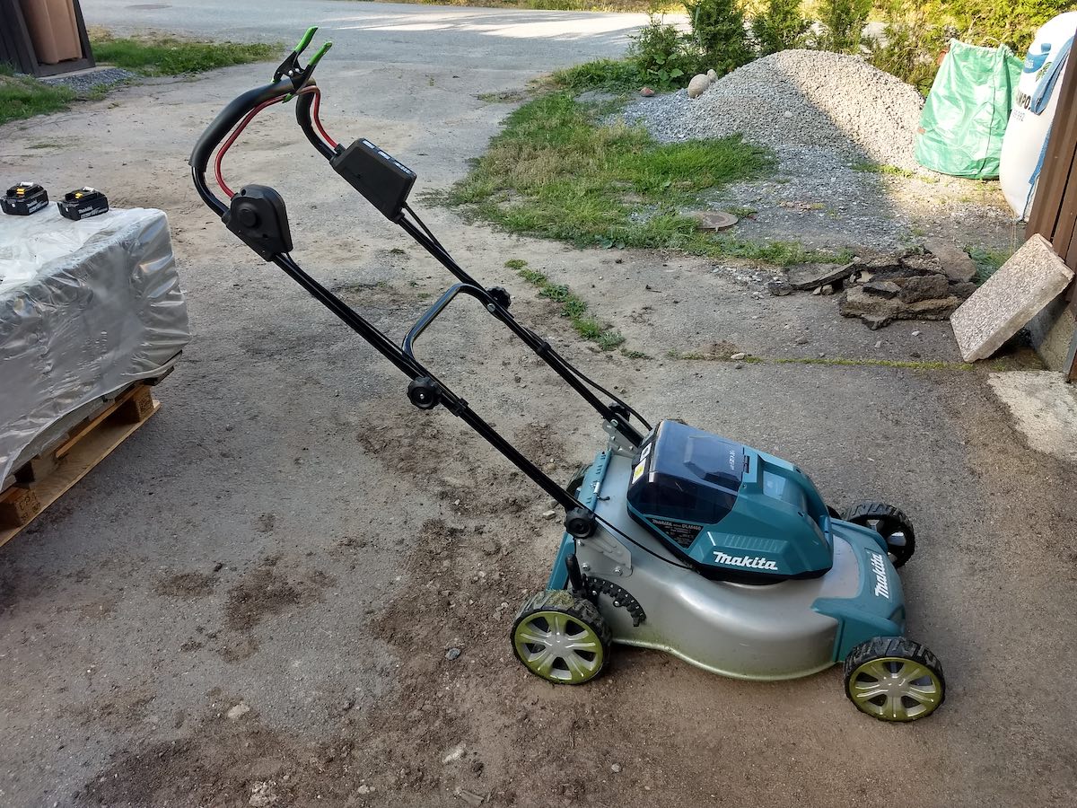 Photo of lawnmower with clamp holding safety handle.