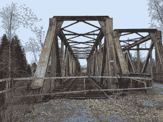 An abandoned, rusty railway bridge.